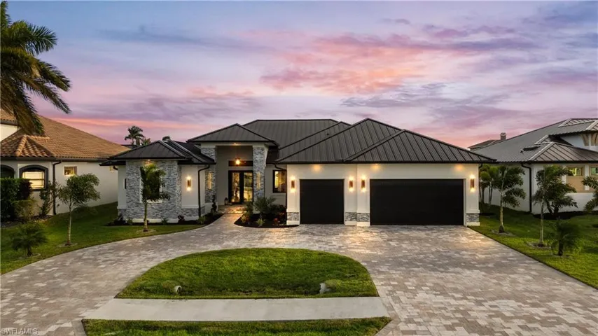 View of front facade featuring a lawn and a garage