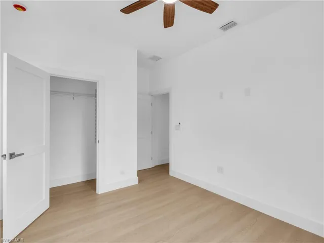 Unfurnished bedroom with light wood finished floors, ceiling fan, and a closet