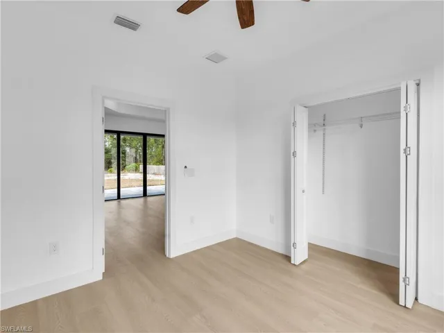 Unfurnished bedroom featuring light wood-type flooring, a ceiling fan, and a closet