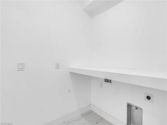 Laundry room featuring light marble finish flooring and hookup for an electric dryer