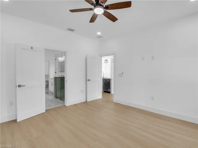 Unfurnished bedroom with light wood finished floors, a ceiling fan, recessed lighting, and connected bathroom