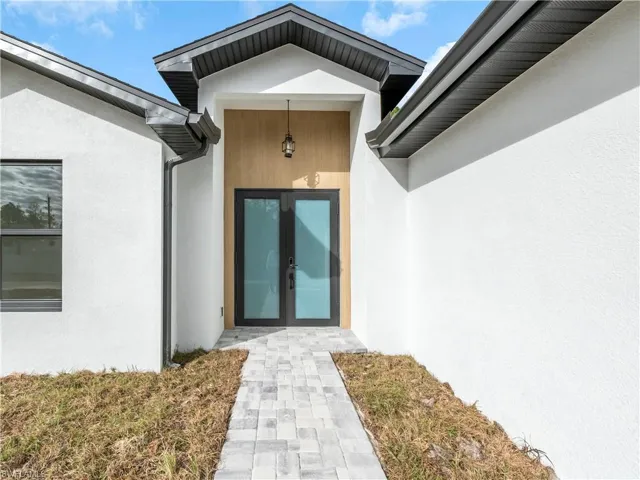 Property entrance with french doors and stucco siding