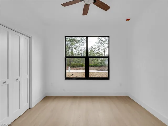 Unfurnished bedroom with light wood-style floors, a closet, and ceiling fan