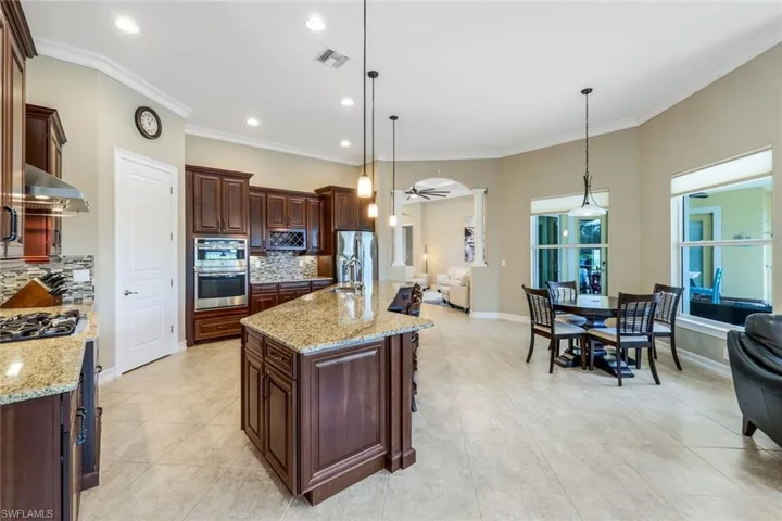 Kitchen featuring open floor plan, visible vents, stainless steel appliances, and exhaust hood