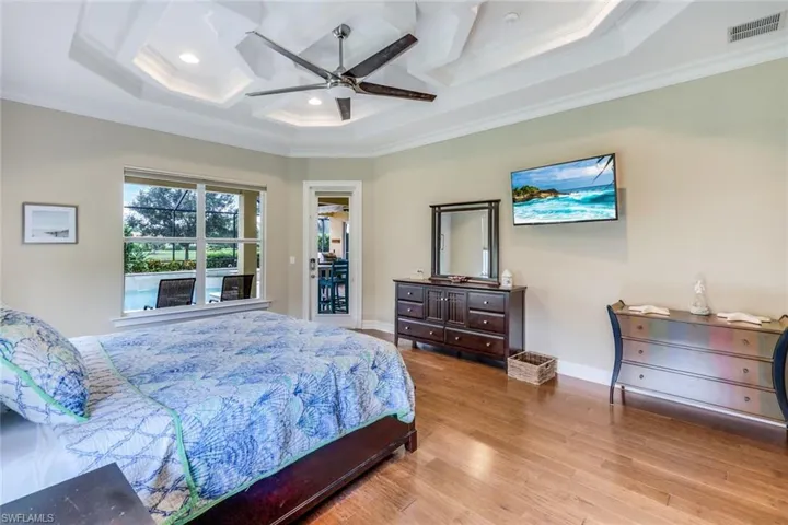 Bedroom featuring visible vents, ornamental molding, baseboards, and wood finished floors