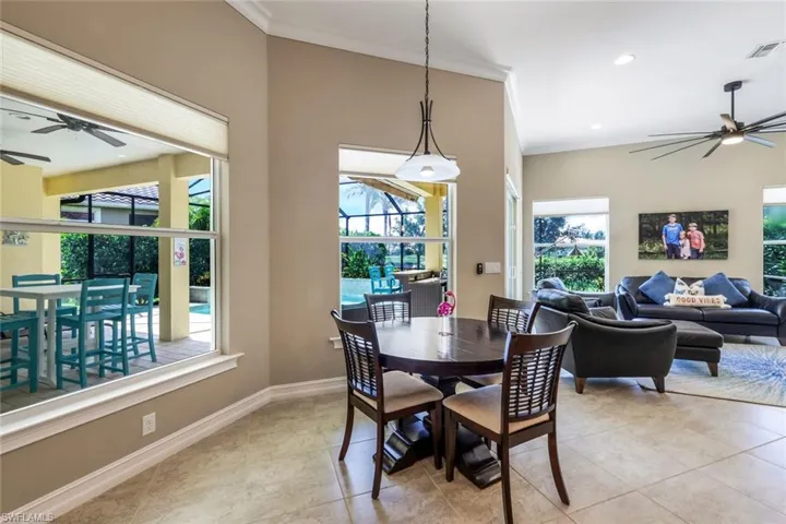 Dining area featuring ornamental molding, visible vents, a healthy amount of sunlight, and a ceiling fan