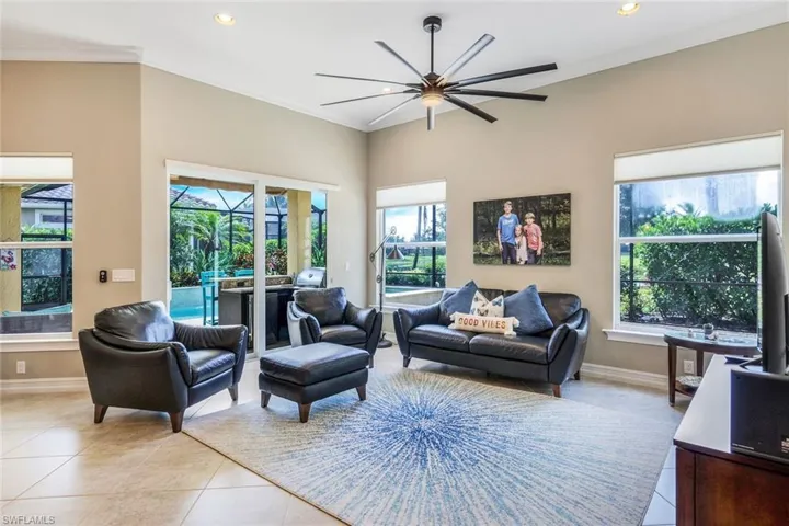 Living room featuring crown molding, a ceiling fan, light tile patterned floors, baseboards, and recessed lighting