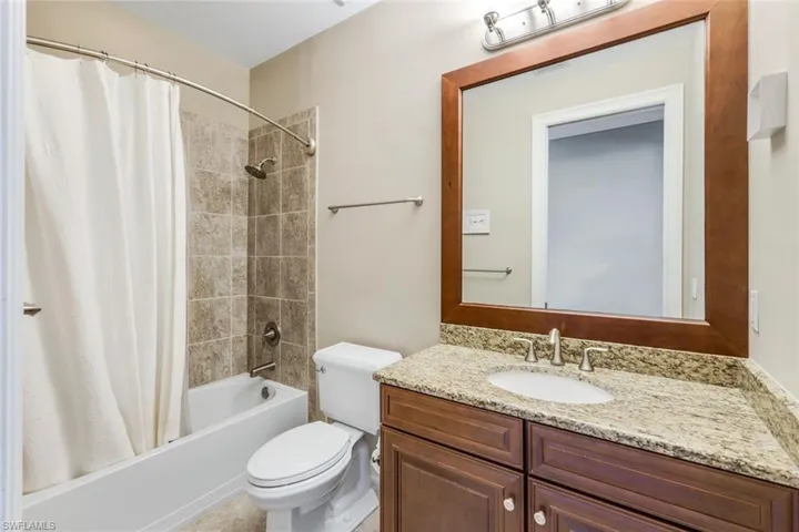 Bathroom with toilet, vanity, and shower / bath combo