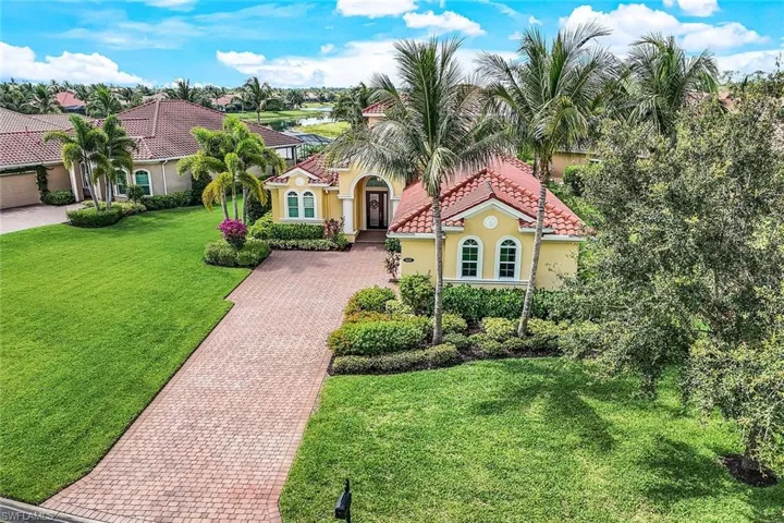 Mediterranean / spanish-style house with a tile roof, a front yard, decorative driveway, and stucco siding