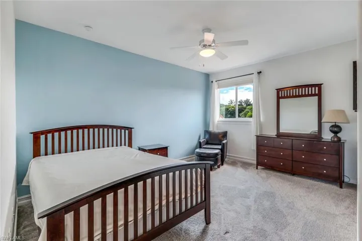 Bedroom with baseboards, carpet floors, and a ceiling fan