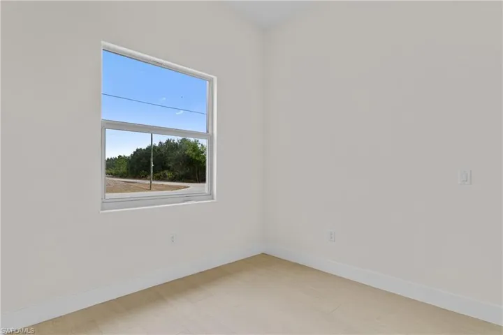 Spare room featuring baseboards and light wood-style floors