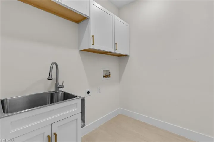 Laundry area featuring cabinet space, light wood finished floors, electric dryer hookup, and hookup for a washing machine