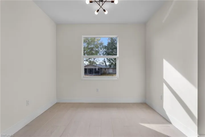 Spare room with a chandelier and light wood-style flooring