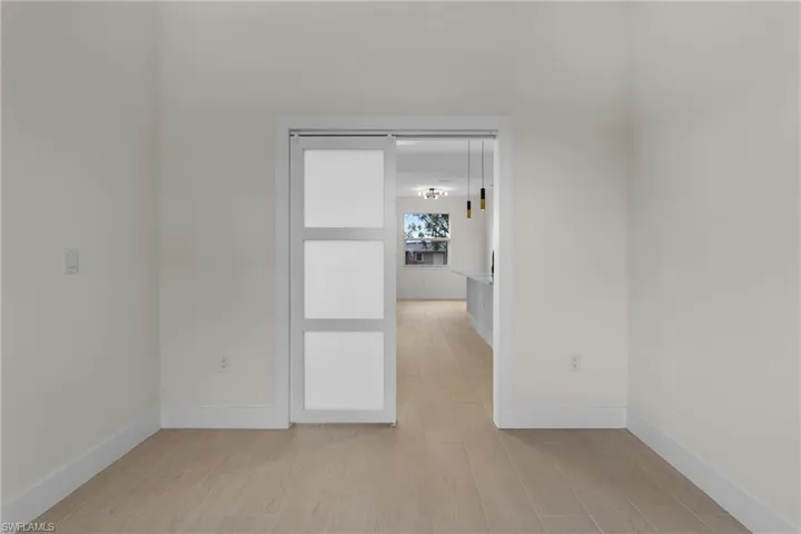 Empty room featuring baseboards and light wood finished floors