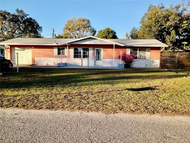 Single story home with a garage, a front lawn, a porch, and stucco siding