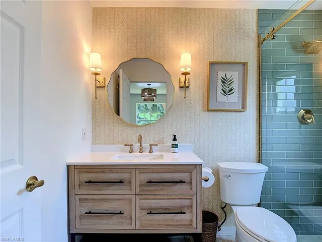 Single vanity with a white countertop and gold-finish faucet