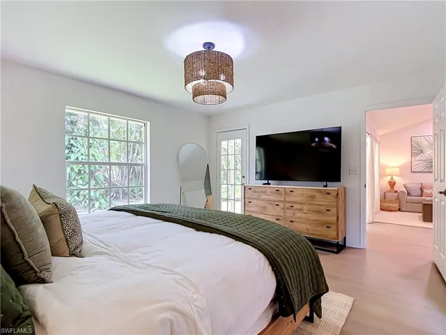 Light-toned wood-finish flooring, white walls, and a two-tiered woven pendant light fixture