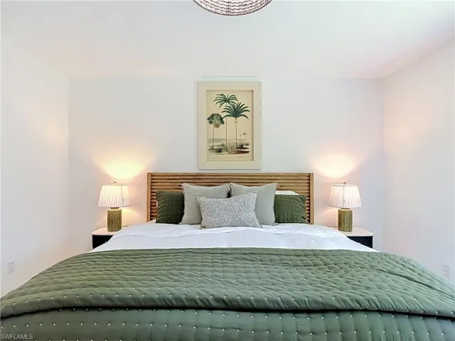 White painted walls, wood panel headboard, and a built-in ceiling light fixture