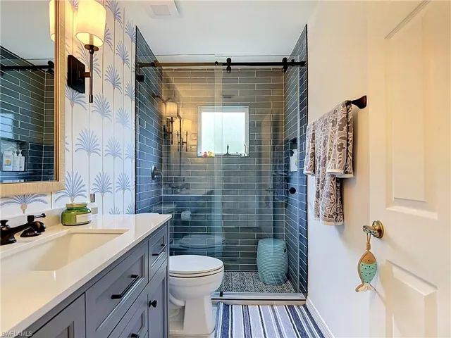 Frameless glass shower enclosure with subway tile surround
