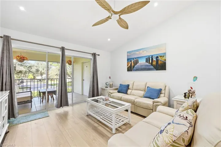 Living room featuring light wood-style flooring, vaulted ceiling, ceiling fan, and recessed lighting