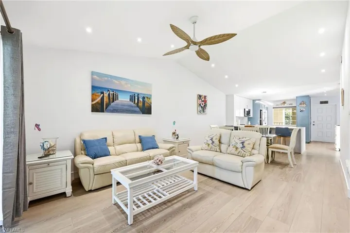 Living room featuring light wood-style floors, lofted ceiling, recessed lighting, and a ceiling fan