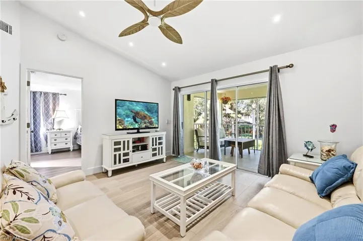 Living room featuring recessed lighting, ceiling fan, light wood-style flooring, and high vaulted ceiling