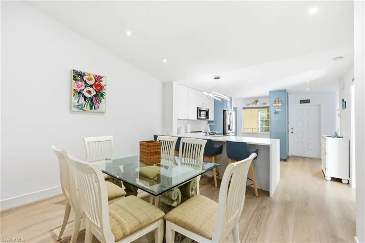 Dining area with light wood-style flooring, recessed lighting, and lofted ceiling