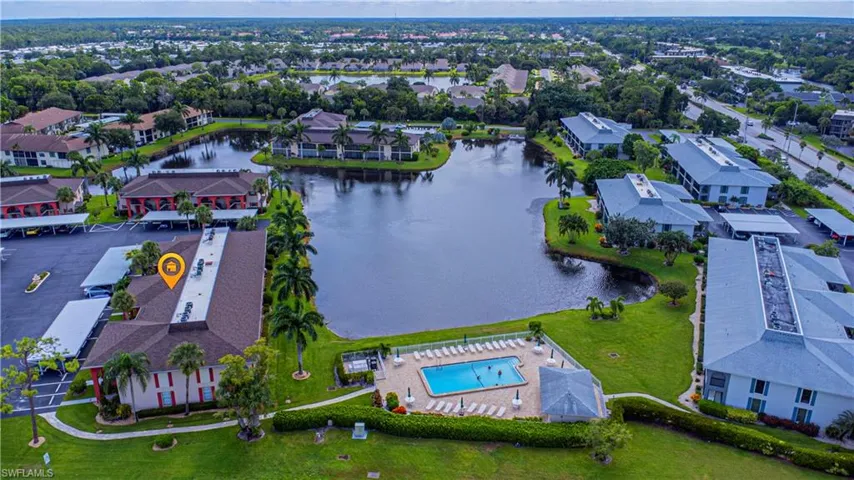 Drone / aerial view featuring the building, lake and pool