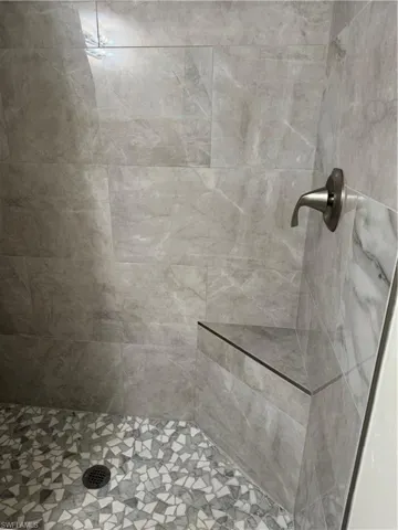 Walk in shower with seating and upgraded tiles.