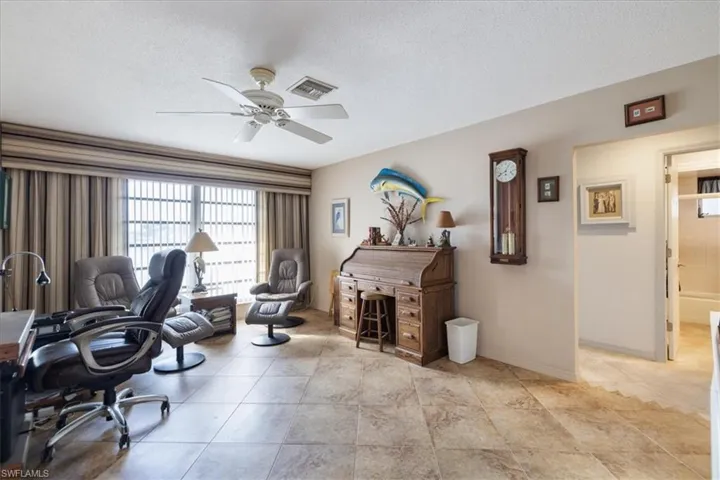 Office space with a ceiling fan, a textured ceiling, and baseboards
