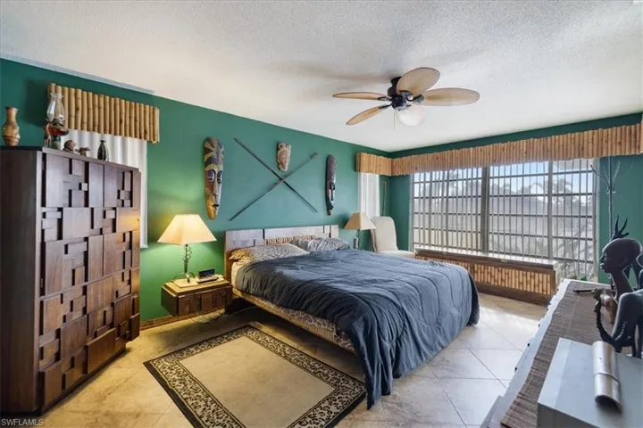 Bedroom with a textured ceiling, ceiling fan, and tile patterned flooring