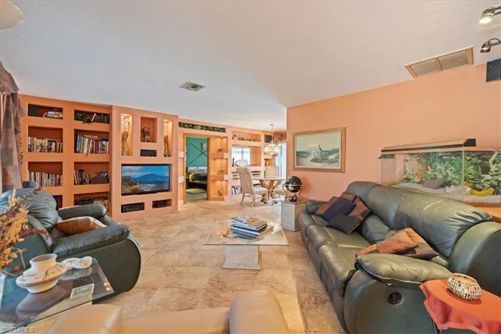 Living room featuring a textured ceiling and built in features