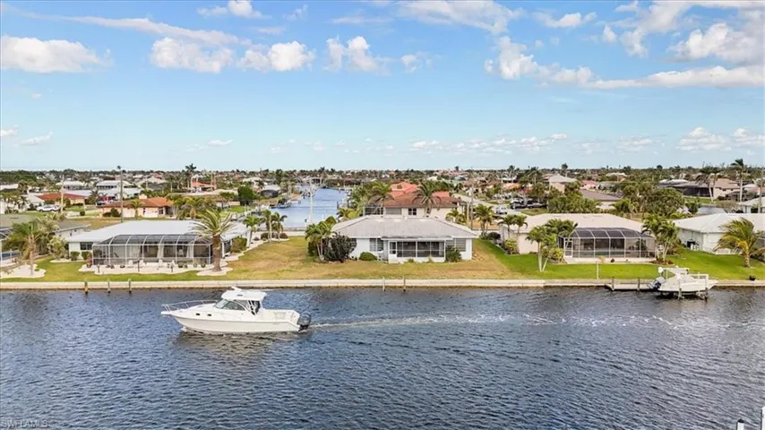 Water view featuring nearby suburban area and a boat dock