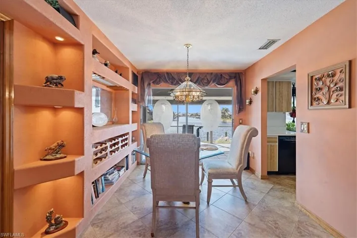 Dining space featuring a chandelier, a textured ceiling, and baseboards