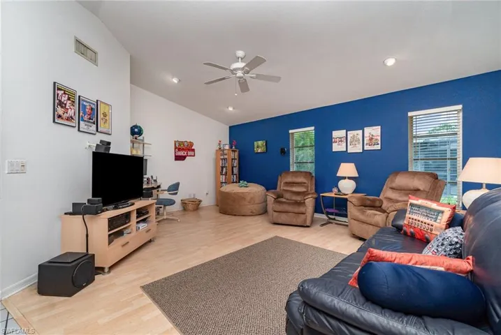 Living room featuring vaulted ceiling, ceiling fan, and light hardwood / wood-style floors