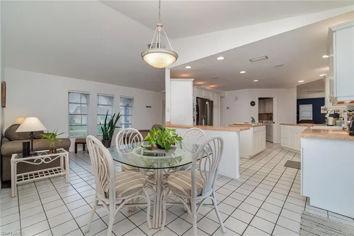 Tiled dining room with lofted ceiling