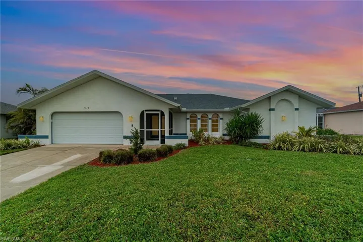 Ranch-style house with a garage and a yard