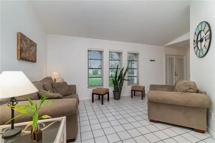 Living room with light tile patterned floors and vaulted ceiling