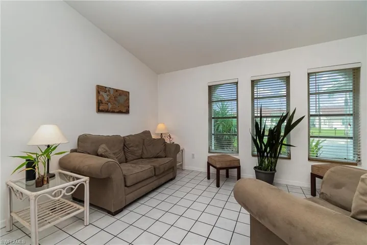 Living room featuring vaulted ceiling and light tile patterned floors
