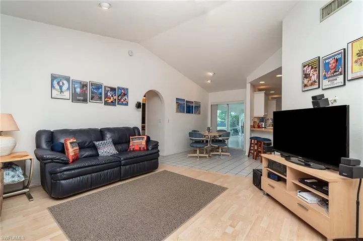 Living room with vaulted ceiling and light hardwood / wood-style floors