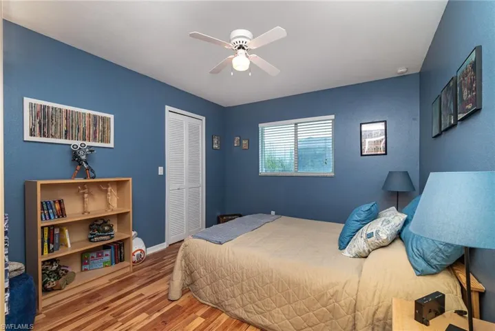 Bedroom with ceiling fan, hardwood / wood-style floors, and a closet