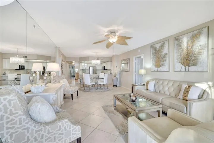 Living room with hanging lights, light tile patterned floors, and a ceiling fan