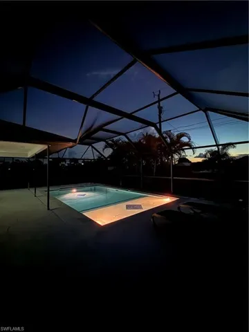 Outdoor pool featuring a lanai, a sunroom, a patio, and a hot tub