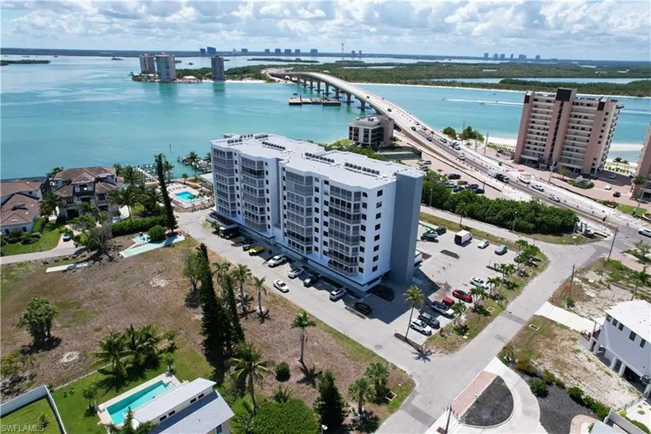 High-rise condominium building featuring multiple balconies, on-site parking, and direct water frontage
