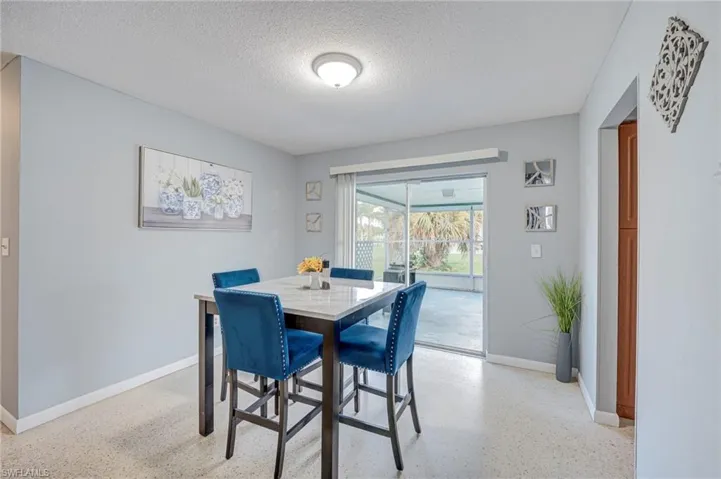 Interior space featuring neutral wall paint, polished terrazzo flooring, and sliding glass doors with access to an enclosed patio area
