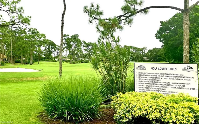 View of home's community featuring a yard, view of wooded area, and view of golf course