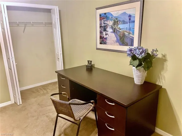 Office area with baseboards and light colored carpet
