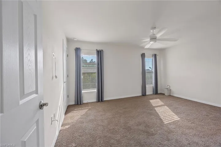 Unfurnished room featuring carpet and ceiling fan