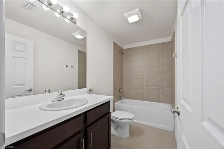 Full bathroom featuring vanity, tub / shower combination, and light tile patterned flooring