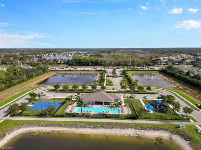 Drone / aerial view of a pool area and a nearby body of water